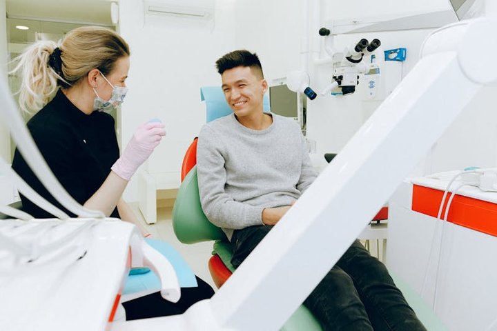 Dentista realizando atendimento odontológico com equipamento portátil em paciente acamado