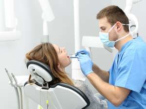 Dentista realizando limpeza dental profissional de qualidade em Brasília