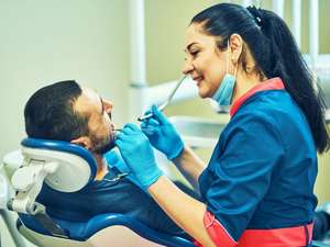 Dentista orientando paciente sobre higiene bucal para tratar mau hálito em Brasília